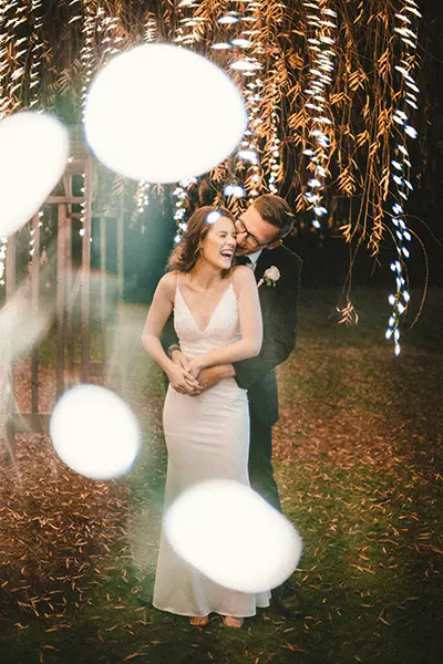 Bride & Groom dancing under lights strung through the trees